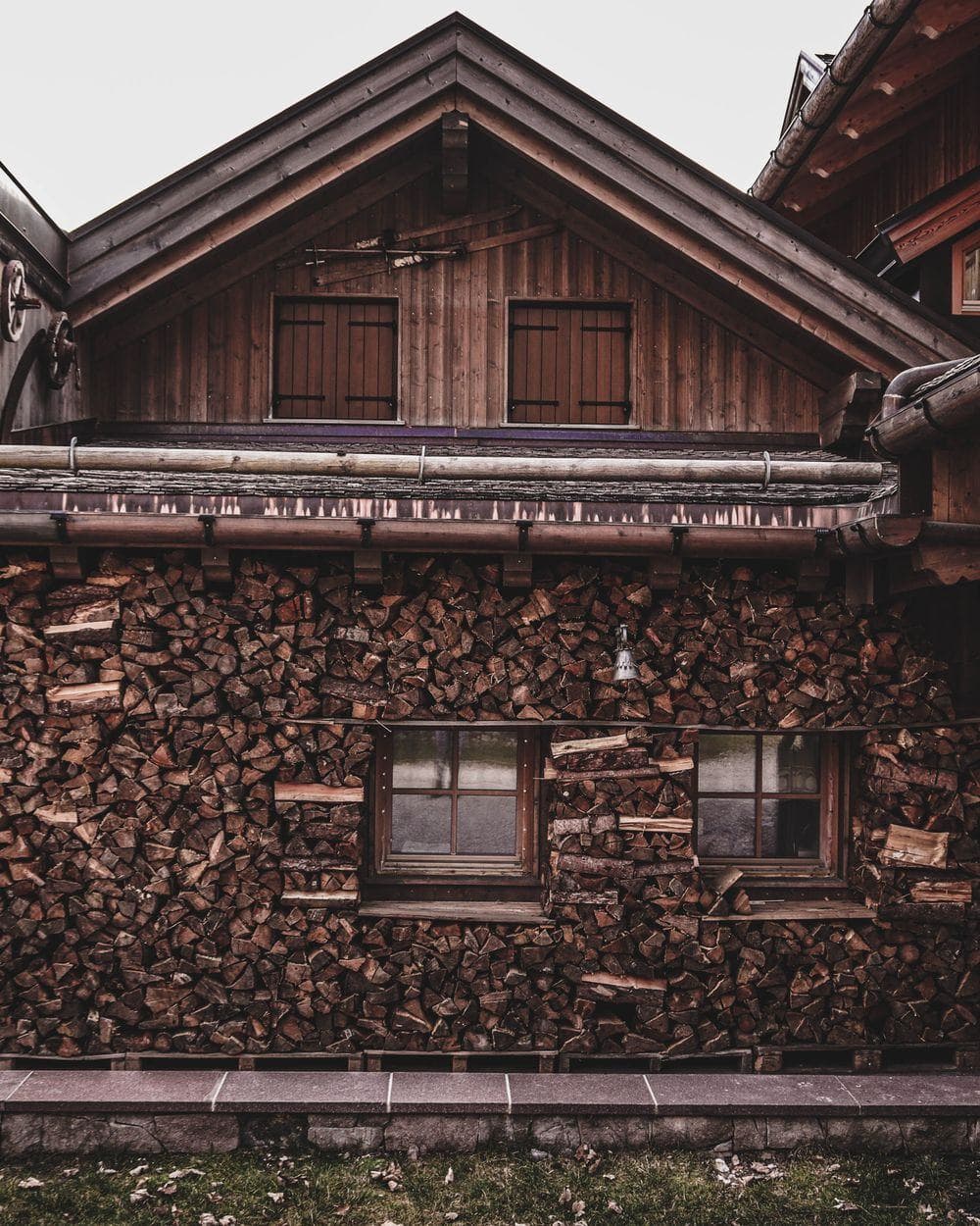 Holzchalet mit gestapeltem Brennholz an der Fassade