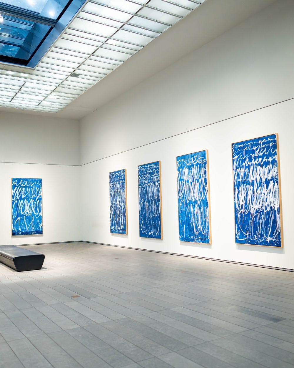 Weißer Galerieraum mit blauen abstrakten Bildern