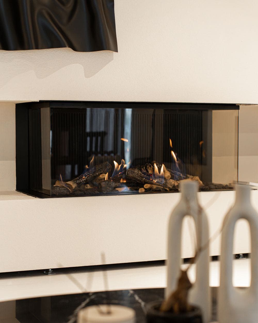 Moderner Kamin mit umlaufender Glasscheibe