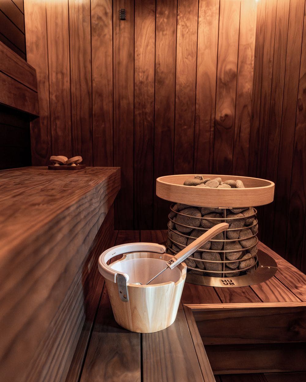 Sauna mit Holzbänken, Kübel und Kelle
